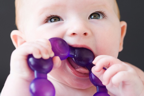 Khi bị sốt mọc răng bé sẽ thấy ngứa lợi và thích cho đồ chơi lên miệng